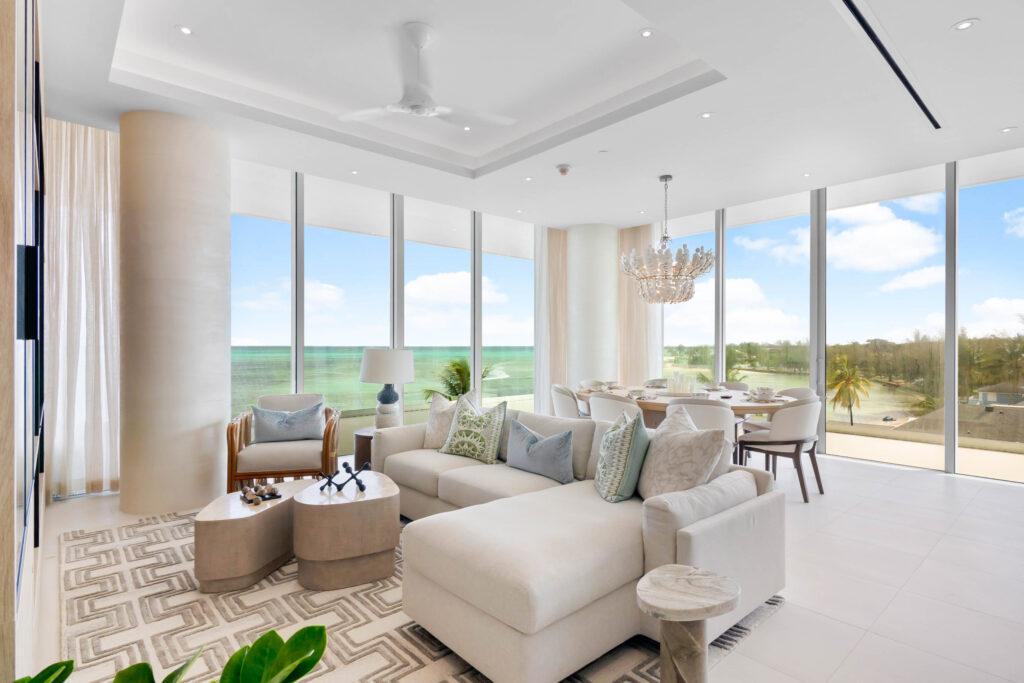 Penthouses at Goldwynn Three-Bedroom Model Residence modern living and dining room with large floor-to-ceiling windows offering ocean views, neutral furnishings, chandelier, and natural light.