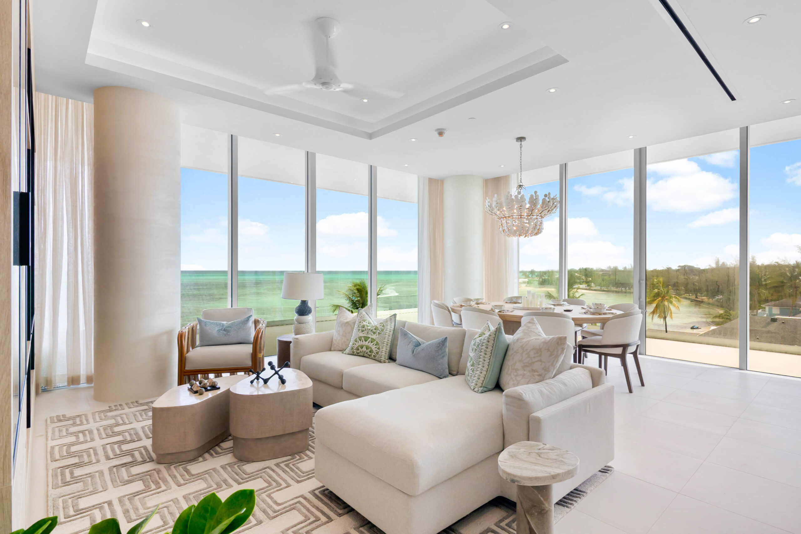 Penthouses at Goldwynn Three-Bedroom Model Residence modern living and dining room with large floor-to-ceiling windows offering ocean views, neutral furnishings, chandelier, and natural light.